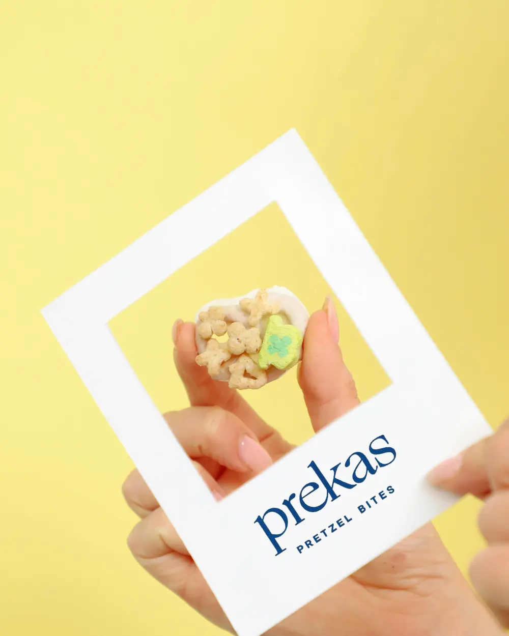 Una mano sostiene un marco de prekas con un pretzel de cereal en el centro